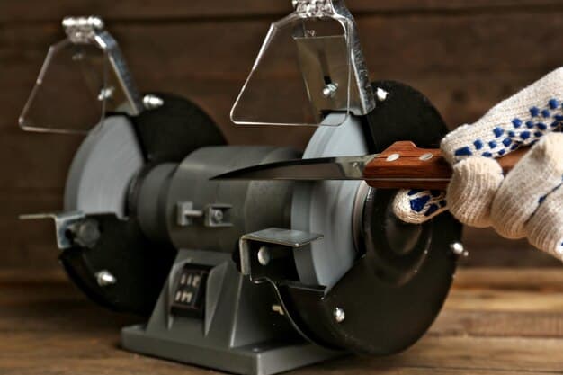 Knife sharpener and hand with knife on wooden table closeup