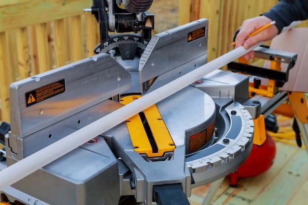 Closeup of mature man sawing lumber with sliding compound miter saw outdoors