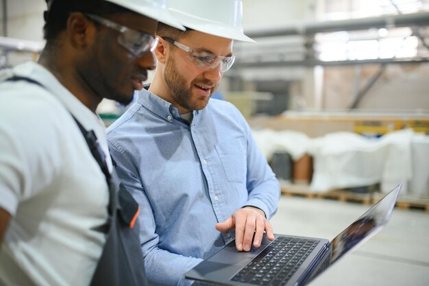 Quality engineer reviewing a digital SOP audit trail on a laptop, showing version history, electronic signatures, and step-by-step photo evidence captured by an operator